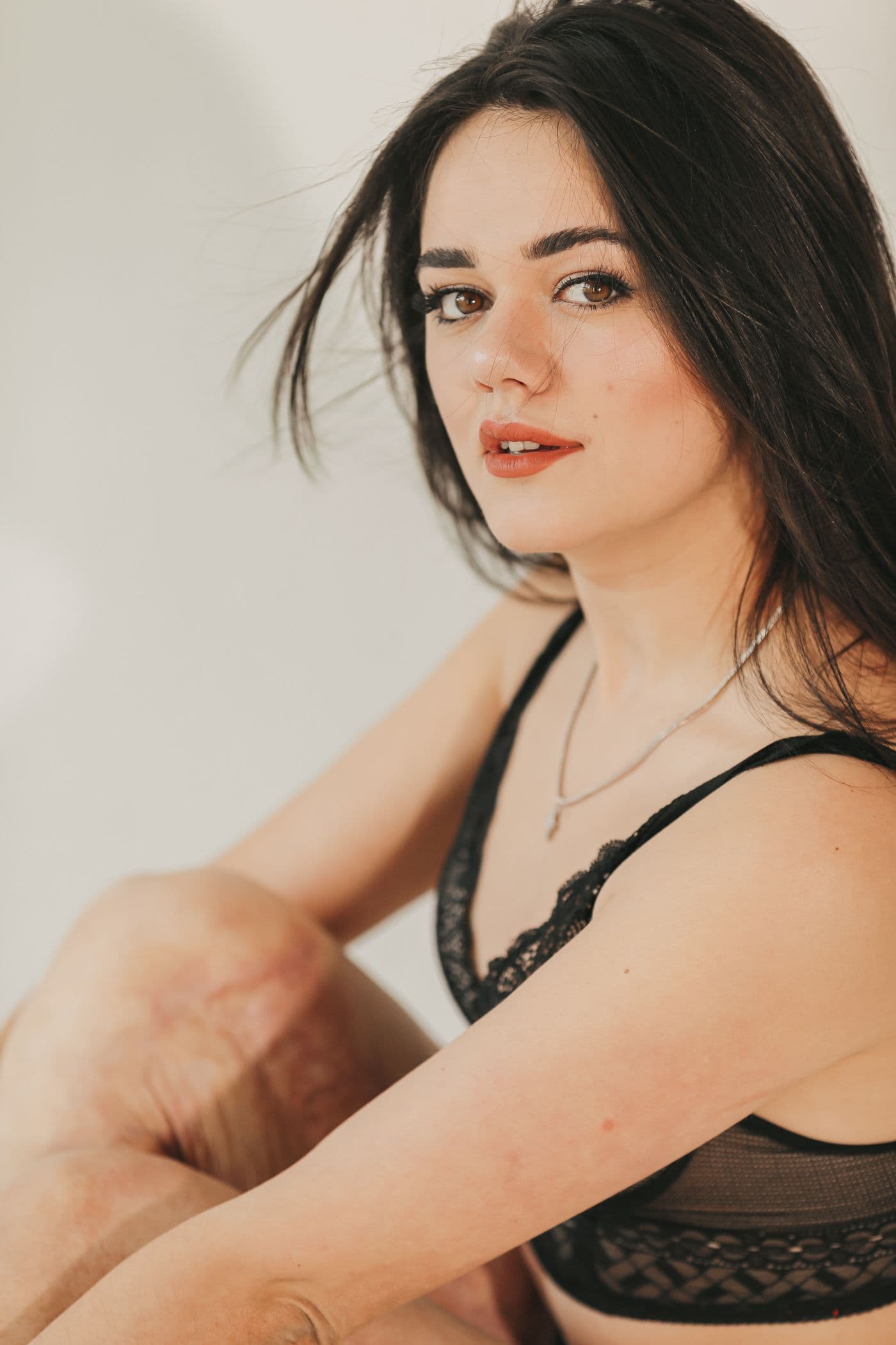 Woman in a black lace bralette looking over her shoulder